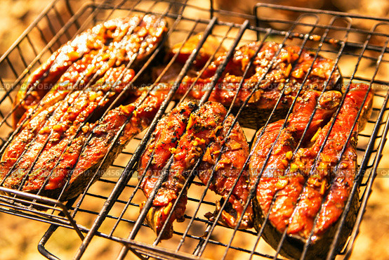 grilling salmon steak with ginger marinade in grid over barbecue. Top view grilled salmon on flaming braai. Стоковое фото, агентство Ingram Publishing / Фотобанк Лори