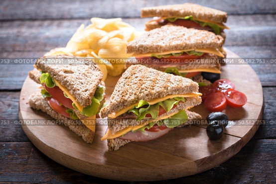 Group of club sandwiches with potato chips on wooden bacground,selective focus . Стоковое фото, агентство Ingram Publishing / Фотобанк Лори
