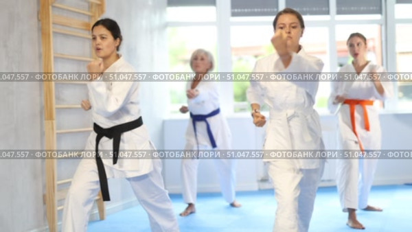 Group of female karatekas practicing karate technique in gym. Стоковое видео, видеограф Яков Филимонов / Фотобанк Лори