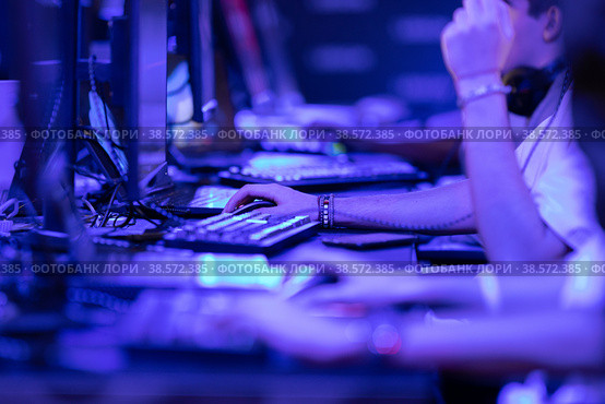 Group of guys collectively play an online game in a competition in blue lighting - esports. Стоковое фото, фотограф Константин Шишкин / Фотобанк Лори