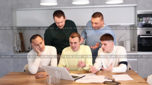 Group of men huddling around laptop at kitchen table, discussing problems and comforting distressed friend while gathering at home bachelor party. Стоковое видео, видеограф Яков Филимонов / Фотобанк Лори