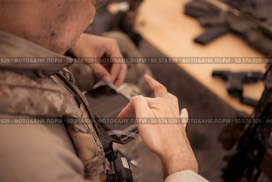 Group of soldiers in camouflage uniforms hold weapons in a field tent, Plan and prepare for combat training. Стоковое фото, агентство Ingram Publishing / Фотобанк Лори