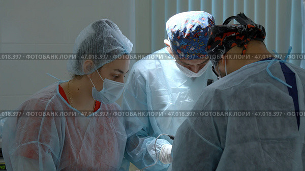 Group of surgeons working in operating room at hospital. Стоковое фото, фотограф David Kashakhi / Фотобанк Лори