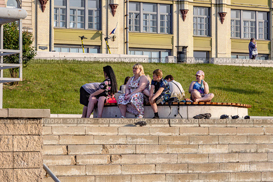 Группа людей, отдыхающих на скамейке на Нижневолжской набережной Нижнего Новгорода летом. Редакционное фото, фотограф Владимир Шипикин / Фотобанк Лори