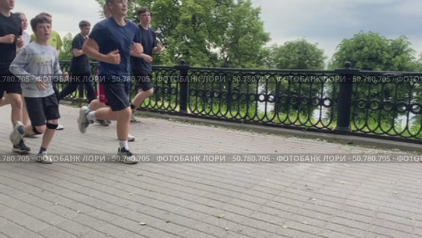 Группа подростков в спортивной форме бежит по Волжской набережной в Ярославле недалеко от речного вокзала. Редакционное видео, видеограф Владимир Шипикин / Фотобанк Лори