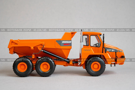 Грузовой самосвал Doosan южнокорейского производства — игрушечная миниатюрная модель на сером фоне (2023 год). Редакционное фото, фотограф Дорощенко Элла / Фотобанк Лори