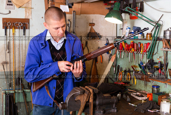 Gunsmith examines and checks appearance of the semi automatic rifle. Стоковое фото, фотограф Яков Филимонов / Фотобанк Лори