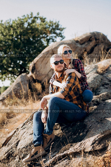 Guy and girl in caged shirts and trekking shoes on granite rocks. Стоковое фото, агентство Ingram Publishing / Фотобанк Лори