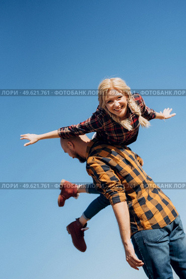 Guy and girl in caged shirts and trekking shoes on granite rocks. Стоковое фото, агентство Ingram Publishing / Фотобанк Лори