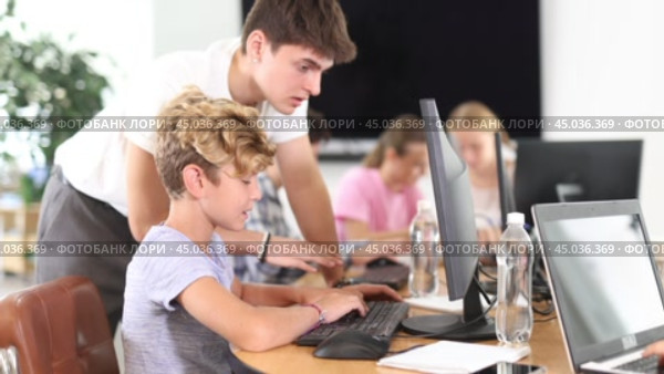 Guy teacher teaches boy student to work with computer. Стоковое видео, видеограф Яков Филимонов / Фотобанк Лори