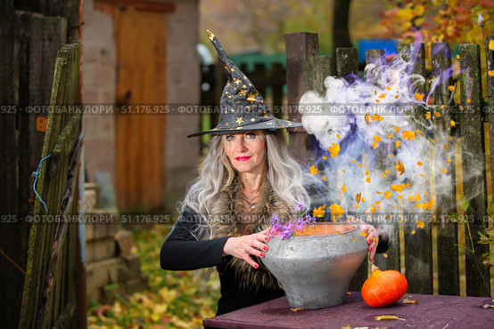 Halloween a woman with a magic bowler hat witch conjures, performs witchcraft in a creepy old magical house. Стоковое фото, фотограф Лазаренко Светлана / Фотобанк Лори