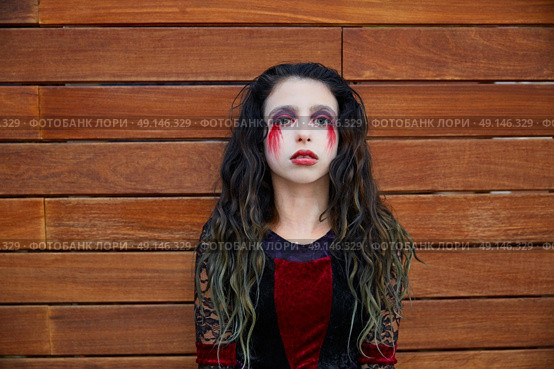 Halloween kid girl custome with bloody makeup on wooden wall. Стоковое фото, агентство Ingram Publishing / Фотобанк Лори