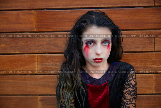 Halloween kid girl custome with bloody makeup on wooden wall. Стоковое фото, агентство Ingram Publishing / Фотобанк Лори