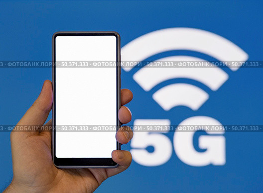 hand holding phone with 5g symbol background. Стоковое фото, агентство Ingram Publishing / Фотобанк Лори