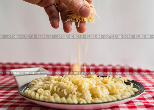 hand sprinkling cheese pasta. Стоковое фото, агентство Ingram Publishing / Фотобанк Лори