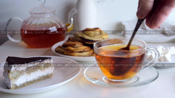 Hand stirs a teaspoon of sugar in a cup. Breakfast with cake. Стоковое видео, видеограф Ирина Толокновская / Фотобанк Лори