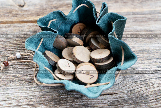 Handmade runes for fortunetelling in leather bag close up. Handmade runes for fortunetelling. Стоковое фото, агентство Ingram Publishing / Фотобанк Лори
