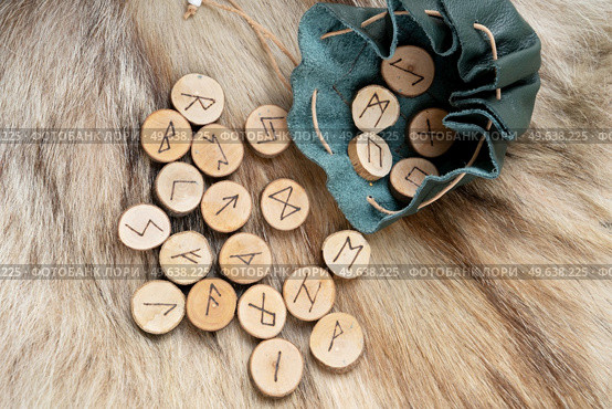 Handmade runes for fortunetelling in leather bag over wolf fur. Handmade runes for fortunetelling. Стоковое фото, агентство Ingram Publishing / Фотобанк Лори