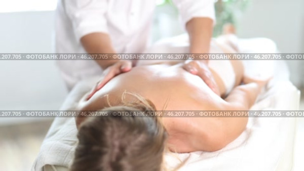 Hands of old masseur conducting back massage for woman client in procedure room. Стоковое видео, видеограф Яков Филимонов / Фотобанк Лори