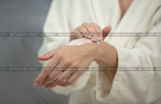 Hands of young woman applies hand skincare cream. Woman model with body cream jar in hands. Winter skin care and wellness concept. Selective focus, copy space. Стоковое фото, фотограф Юлия Тарасова / Фотобанк Лори
