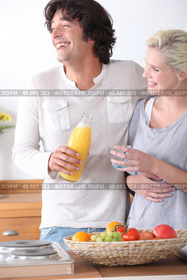 Happy couple stood together in the kitchen. Стоковое фото, агентство Ingram Publishing / Фотобанк Лори
