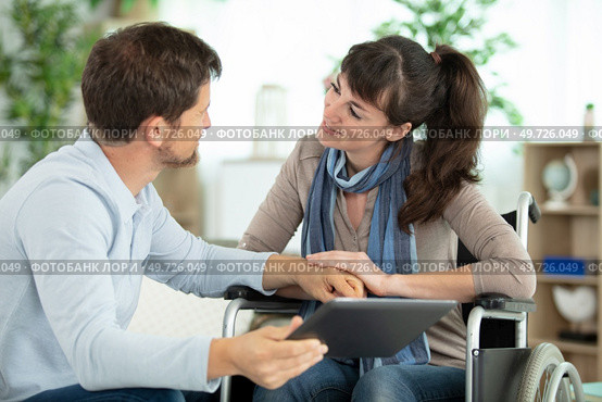 happy loving bearded man and disabled woman using a tablet. Стоковое фото, агентство Ingram Publishing / Фотобанк Лори