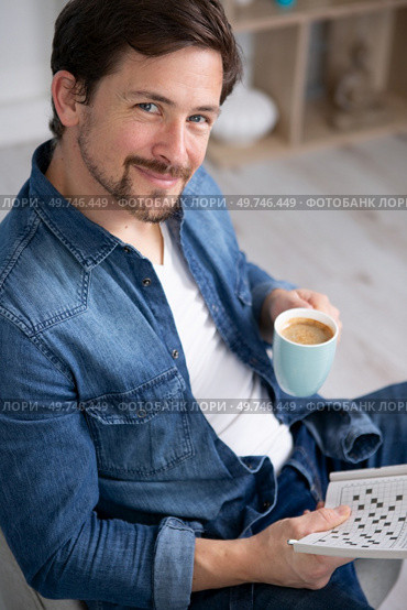 happy man drinking coffee and doing crosswords. Стоковое фото, агентство Ingram Publishing / Фотобанк Лори
