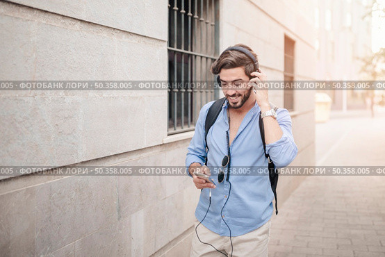happy man walking pavement listening music. Стоковое фото, агентство Ingram Publishing / Фотобанк Лори