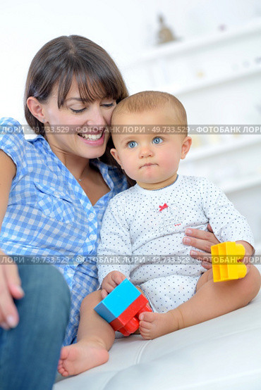 happy mother with baby lying on bed at home. Стоковое фото, агентство Ingram Publishing / Фотобанк Лори