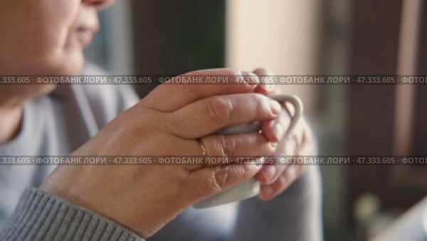 Happy senior woman having a coffee break and thinking at home. Face of an elderly lady feeling nostalgic while having tea during retirement. Elderly woman thinking, decision with wellness and calm. Стоковое видео, видеограф Марина Демидюк / Фотобанк Лори