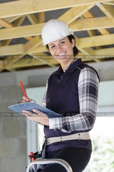 happy woman builder writing on clipboard. Стоковое фото, агентство Ingram Publishing / Фотобанк Лори