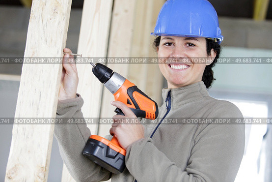 happy woman holding a power drill. Стоковое фото, агентство Ingram Publishing / Фотобанк Лори