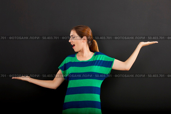 Happy woman making a scale with hands in front of a chalkboard . Стоковое фото, агентство Ingram Publishing / Фотобанк Лори