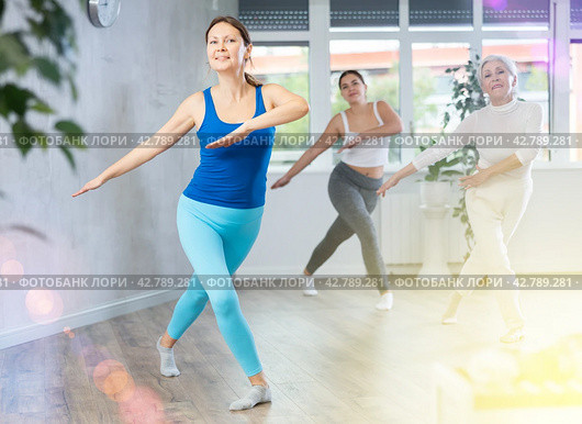Happy woman training vigorous zumba in fitness studio. Стоковое фото, фотограф Яков Филимонов / Фотобанк Лори
