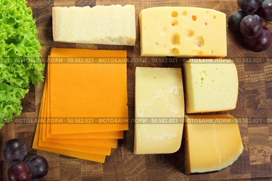 Hard cheeses served on a wooden board. Стоковое фото, агентство Ingram Publishing / Фотобанк Лори