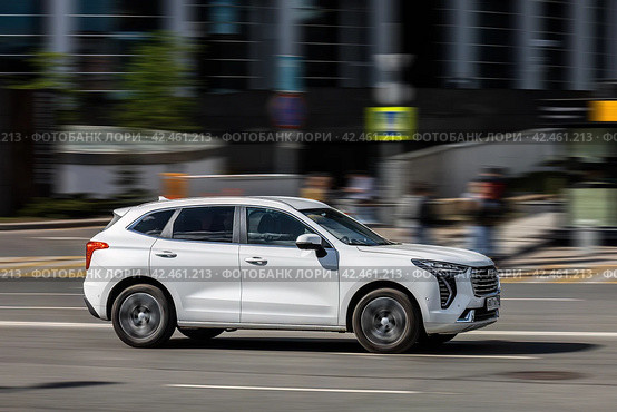 Haval Jolion rides on the road. White compact crossover SUV on the city street in motion. Редакционное фото, фотограф Константин Григорьев / Фотобанк Лори
