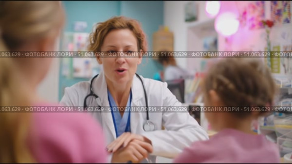 Health professional engages with young patients in a friendly clinic setting. Стоковое AI-видео, аниматор Сергей Толмачёв / Фотобанк Лори