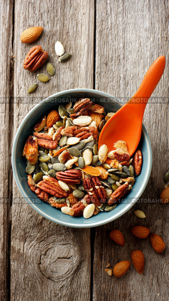 Healthy Nut and Seed Mix in a Bowl for Snacking on a Wooden Table. Стоковое AI-изображение, AI-художник Юлия Гапеенко / Фотобанк Лори