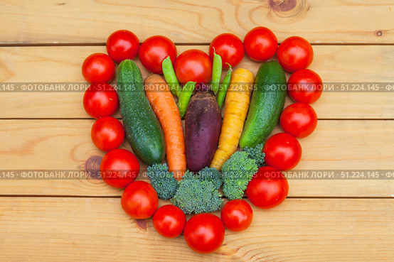Heart healthy vegetables concept. Fresh carrots, beets, broccoli, cucumbers, peas and tomatoes in heart shape on wooden background. organic food. Top view, flat lay, close-up. Стоковое фото, фотограф Виктория Катьянова / Фотобанк Лори