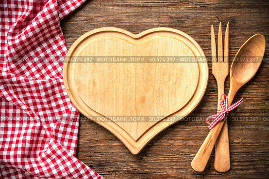 Heart shaped cutting board with a red checkered tablecloth on wooden table. Стоковое фото, агентство Ingram Publishing / Фотобанк Лори