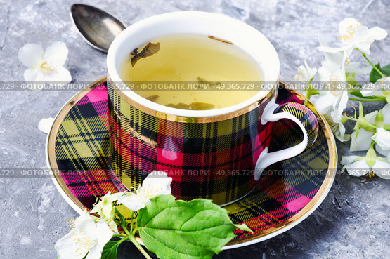 Herbal tea with jasmine. Teacup with tea from jasmine flowers.Green tea. Стоковое фото, агентство Ingram Publishing / Фотобанк Лори