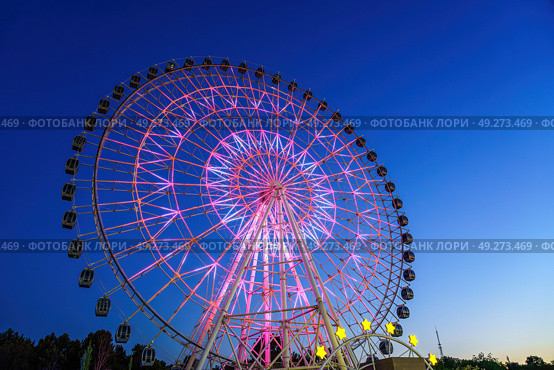 High neon ferris wheel at night in an amusement park Navruz or Anhor in Tashkent, Uzbekistan. (2023 год). Стоковое фото, фотограф Емельянов Евгений Викторович / Фотобанк Лори