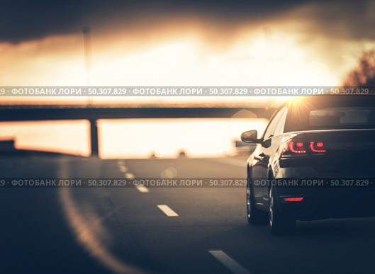 Highway Car Trip. Small Compact Car on the Highway During Sunset. Стоковое фото, агентство Ingram Publishing / Фотобанк Лори