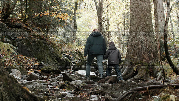 Hikers mother and child hiking up the extreme hill covered with tree roots at fall. Стоковое фото, фотограф David Kashakhi / Фотобанк Лори
