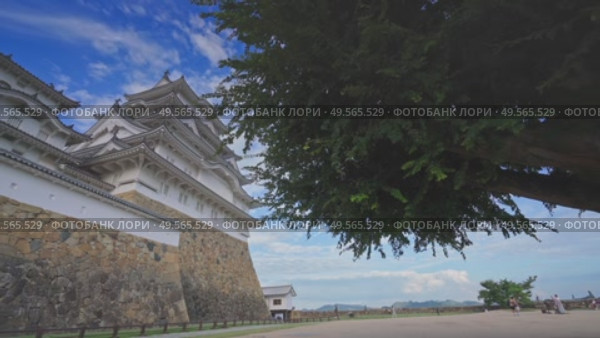 Himeji, Japan - Sep 24 2024, 4k, panoramic view of Himeji Castle, White Heron Castle from below, through tree foliage in daytime with blue sky and clouds, without people, Himeji, Japan. Стоковое видео, видеограф Сергей Богомяко / Фотобанк Лори