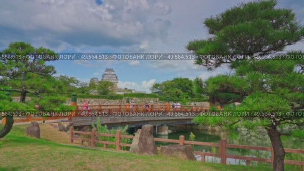 Himeji, Japan - Sep 24 2024, 4k, panoramic view of Sakuramon Bridge and entrance gate, with Himeji Castle, White Heron Castle on background, trees on foreground, at daytime, Himeji, Japan. Редакционное видео, видеограф Сергей Богомяко / Фотобанк Лори
