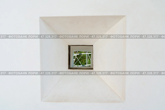 Himeji, Japan - Sep 24 2024, a close-up view of loophole in a form of square through which foliage of trees is visible, fortress wall of Himeji Castle, White Heron Castle, at daytime, Himeji, Japan. Стоковое фото, фотограф Сергей Богомяко / Фотобанк Лори