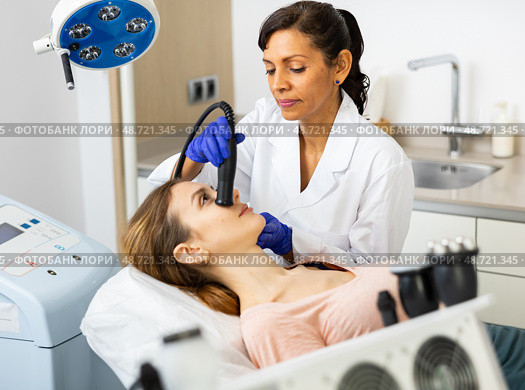 Hispanic woman beautician doing needle-free mesotherapy for young woman. Стоковое фото, фотограф Яков Филимонов / Фотобанк Лори