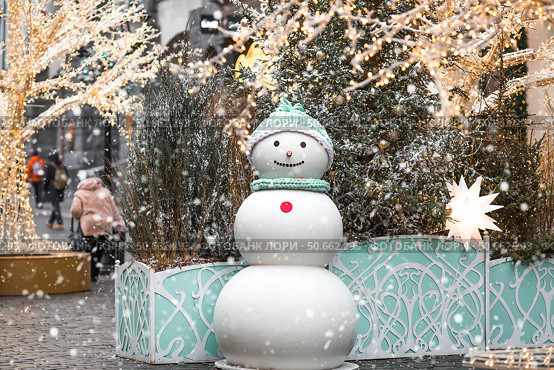 Holiday snowmen on the streets of Moscow. Christmas background with a snowman. Concept of preparation and decoration for the New Year. New Year's postcard 2026. Стоковое фото, фотограф Photojuli / Фотобанк Лори