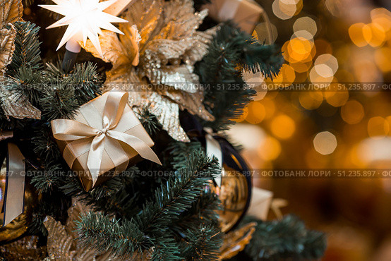 Holiday toys and a golden gift box on a Christmas tree in Moscow. The concept of buying and giving gifts. New Year's card 2026. Стоковое фото, фотограф Photojuli / Фотобанк Лори